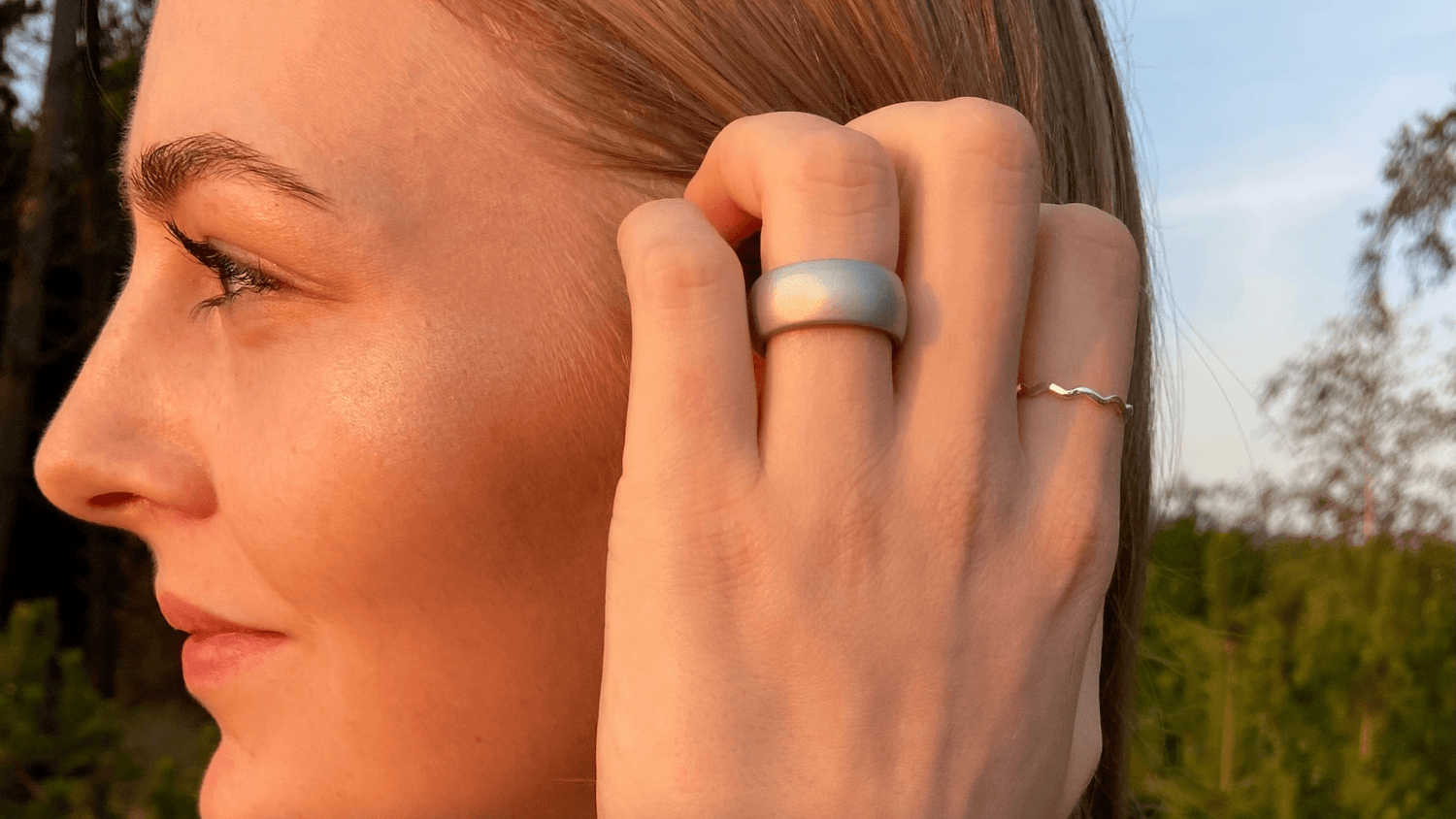 Dame hånd med en chunky silikone ring på i sølv fra newring som er allergivenlig. Newring har en stor samling af farvede ringe i mange styles, som alle er lavet af silikone. Silikoneringe er behagelige og lavet til den aktive kvinde
